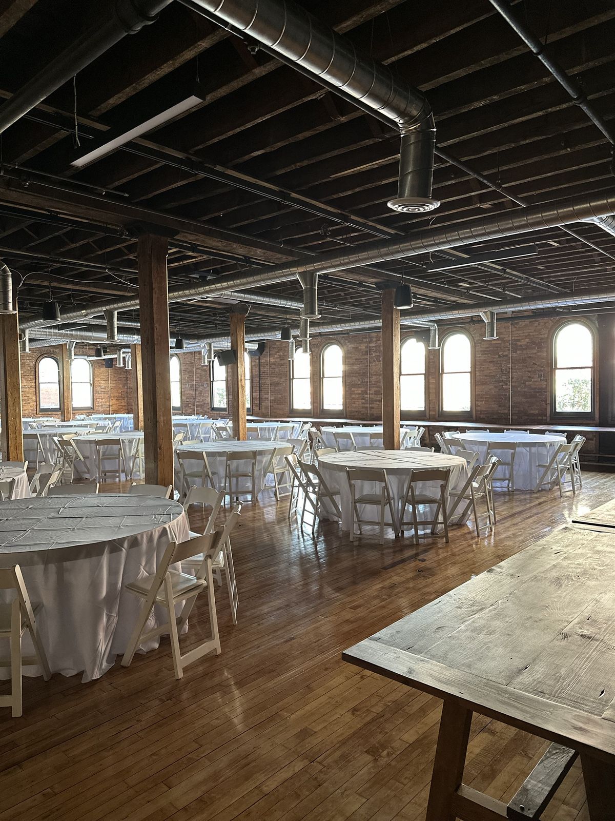 Tall windows along the brick wall, with tables set in white linen
